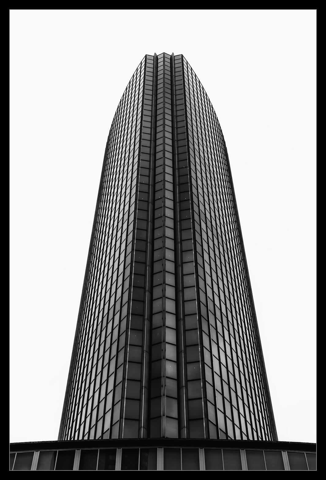 Hochhaus von unten gegen quasi weißen Himmel aufgenommen.