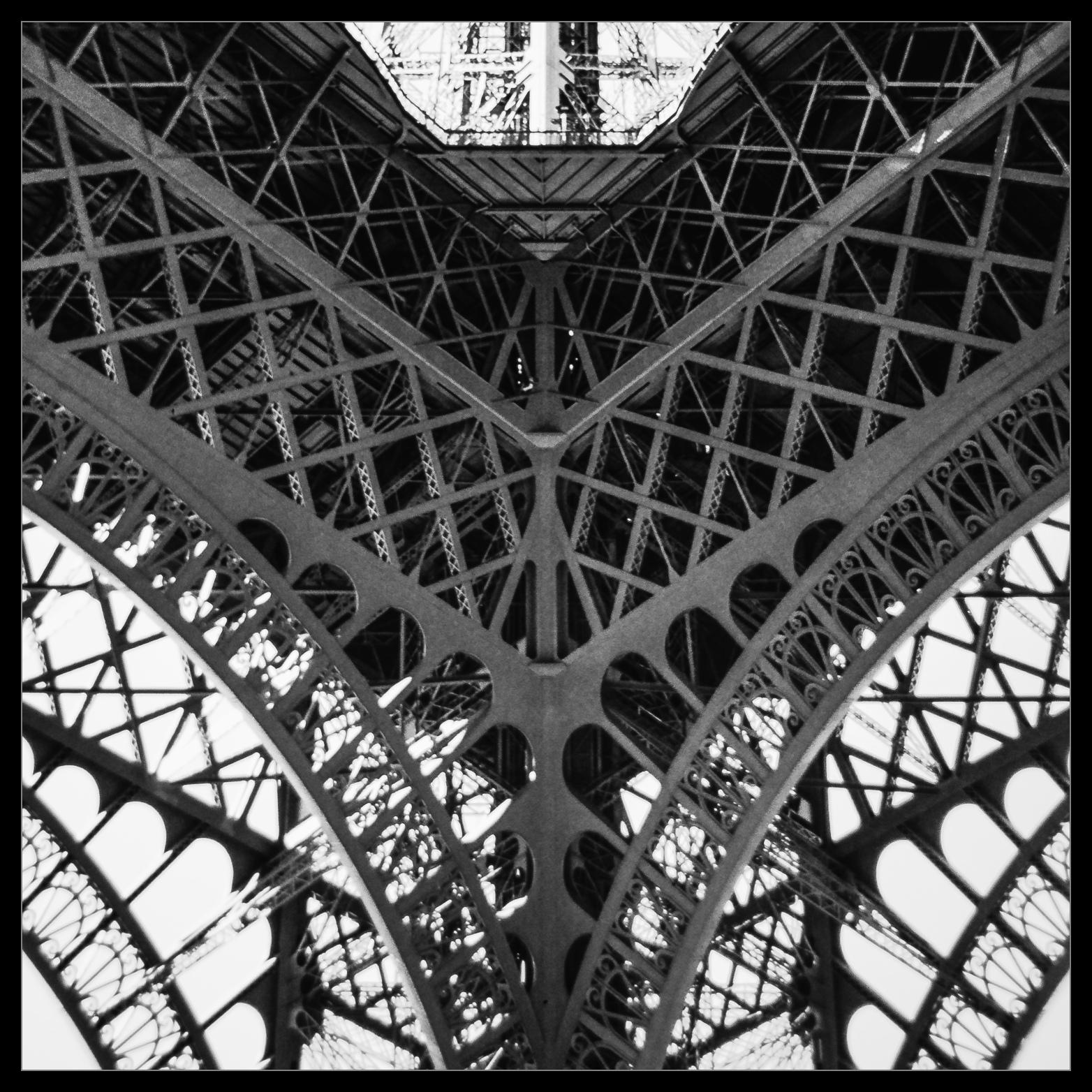 Blick von unten in die Stahlkonstruktion eines von einem Herrn Eiffel errichteten  Turms in Paris.